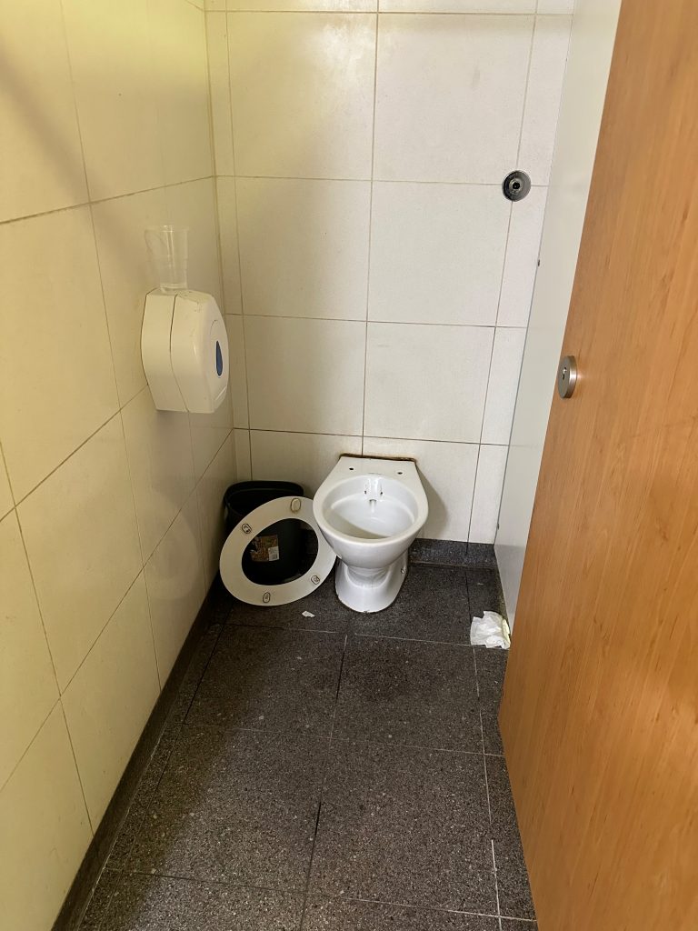 Gatwick Airport South Terminal PHV welfare facility — toilet seat detached and lying on floor, litter visible, 14 May 2026